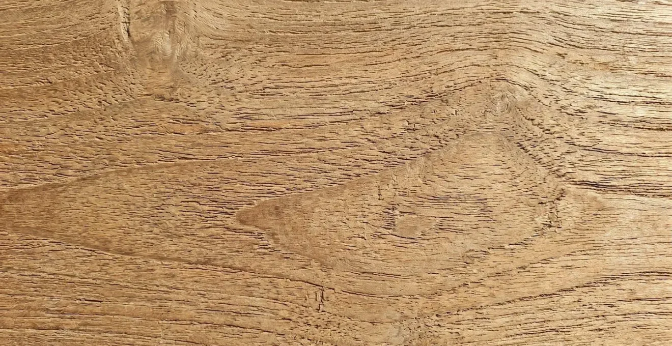 Gros plan sur la texture naturelle d'un mobilier en bois exotique teck exposé à la lumière du soleil
